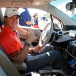 Rory McIlroy and Gary Woodland race in a BMW i3 prior to the 2013 BMW Championship at Conway Farms Golf Club in Illinois